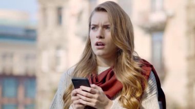 Dışarıda telefonu kullanan üzgün bir kadın. Stresli kız şehir sokağına bakıyor.