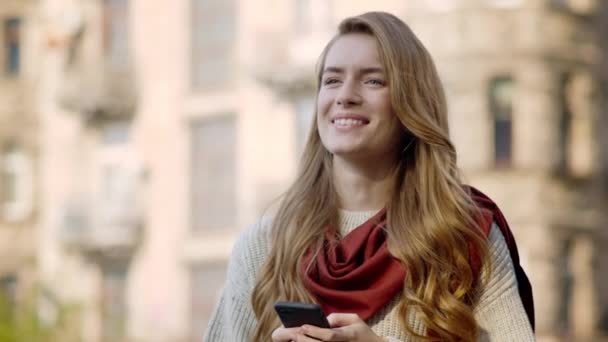 Menina feliz rolando telefone ao ar livre. Sorrindo menina olhando ao redor fora — Vídeo de Stock