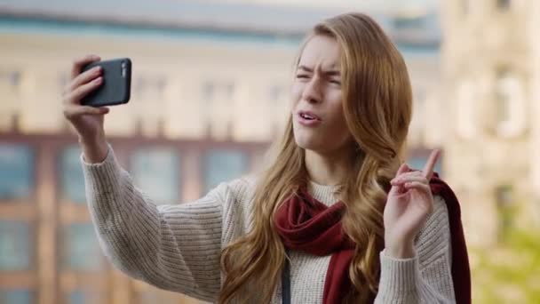 Glada flicka gör videosamtal via telefon. Ung kvinna visar tummen upp framför kameran — Stockvideo