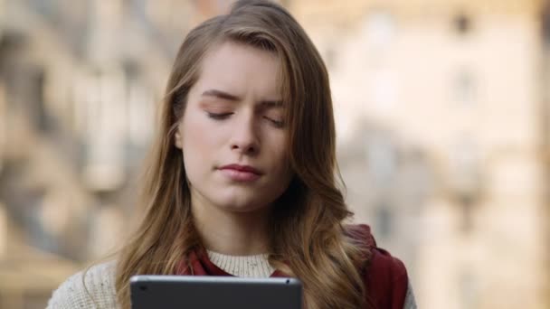 Mujer pensativa sosteniendo la tableta al aire libre. Chica seria mirando pantalla de la tableta — Vídeos de Stock