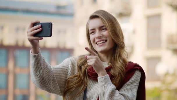 Menina feliz ter chamada de vídeo por telefone ao ar livre. Mulher alegre usando telefone — Vídeo de Stock