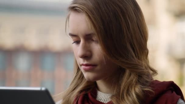 Zdenerwowana dziewczyna trzymająca tabletkę na zewnątrz. Smutna kobieta otrzymująca wiadomość na tablecie. — Wideo stockowe