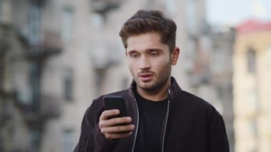 Dışarıda telefonu kullanan üzgün bir adam. Dışarıda mesaj alan adam hayal kırıklığına uğradı.