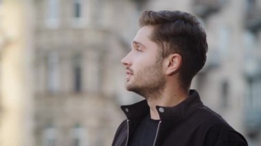 Hippi adam dışarıya bakıyor. Yakışıklı adam dışarıda gülümsüyor.