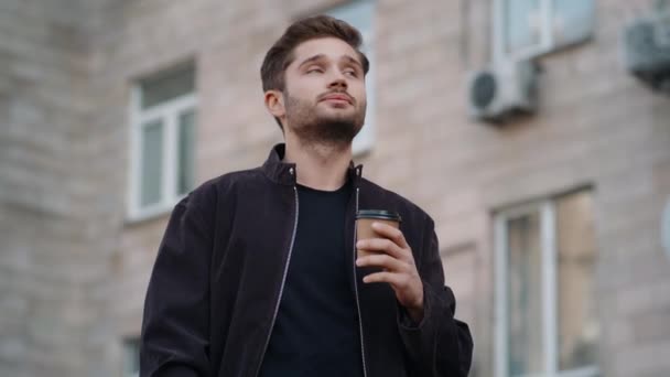 Un hombre guapo bebiendo café afuera. Tipo positivo disfrutando del té al aire libre . — Vídeos de Stock