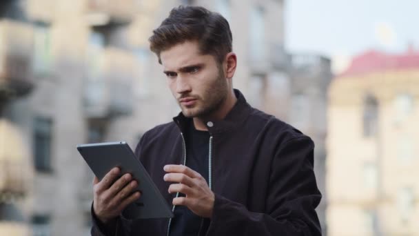 El tipo malvado tiene videollamada afuera. Hombre enojado usando tableta al aire libre — Vídeos de Stock