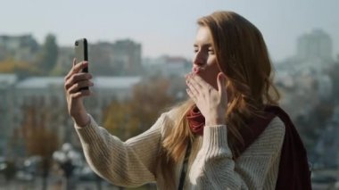 Dışarıda telefonu tutan hoş bir kadın. Çekici bir kız telefon kamerası gibi görünüyor.