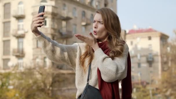 Hipster kvinna gör selfie på telefon utomhus. Söt flicka poserar för kameran. — Stockvideo