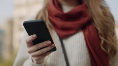 Kadın elleri dışarıdaki cep telefonunu arıyor. Gülümseyen kız akıllı telefondan arıyor..