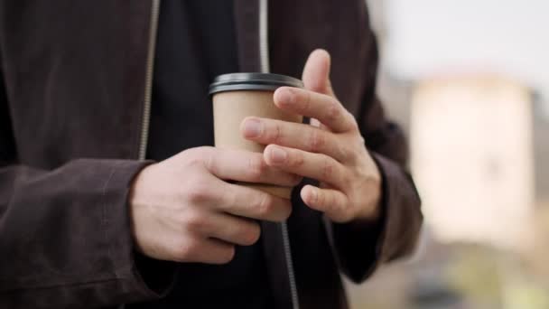 Mano de hombre sosteniendo bebida caliente para llevar. Chico mano caliente con taza de papel . — Vídeos de Stock