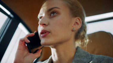 Üzgün iş kadını cep telefonundan konuşuyor. Üzgün kız arabada telefonla oturuyor.