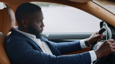 Arabada tek başına araba süren afro adamın yan görüntüsü. Afrikalı adam modern araca biniyor