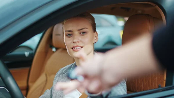 Closeup woman receiving car keys to new vehicle. Businesswoman sitting in car