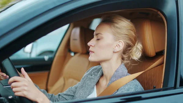 Zbliżenie bizneswoman siedzi za kierownicą. Kobieta tańcząca w samochodzie — Zdjęcie stockowe