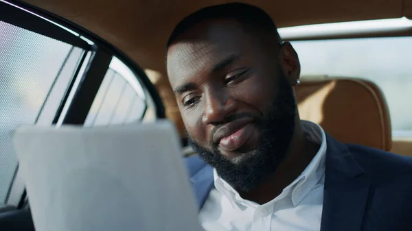 一个快乐的非洲商人在车上看文件的画像。微笑的男人 — 图库照片