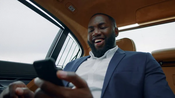 Feliz hombre de negocios celebrando la victoria en el coche. Afro chico haciendo sí gesto —  Fotos de Stock