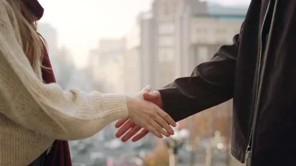 Erkek ve kadın eli tebriklerimizi sunuyoruz. Bilinmeyen çift dışarıda el sıkışıyor..