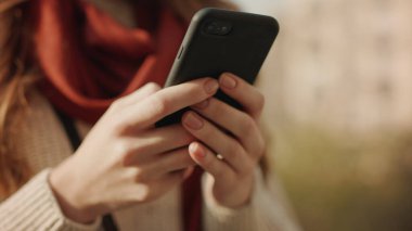 Kadın elleri dışarıda telefonla mesaj yazıyor. Akıllı telefon yazan bilinmeyen kız.