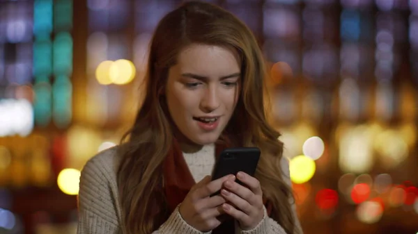 Mulher surpresa conversando telefone celular ao ar livre. Menina alegre olhando celular . — Fotografia de Stock