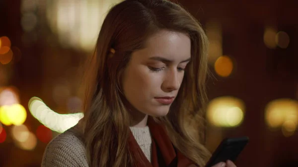 Koncentrált hölgy SMS-ezik mobiltelefonnal a szabadban. Komoly lány keres mobiltelefon képernyőn — Stock Fotó
