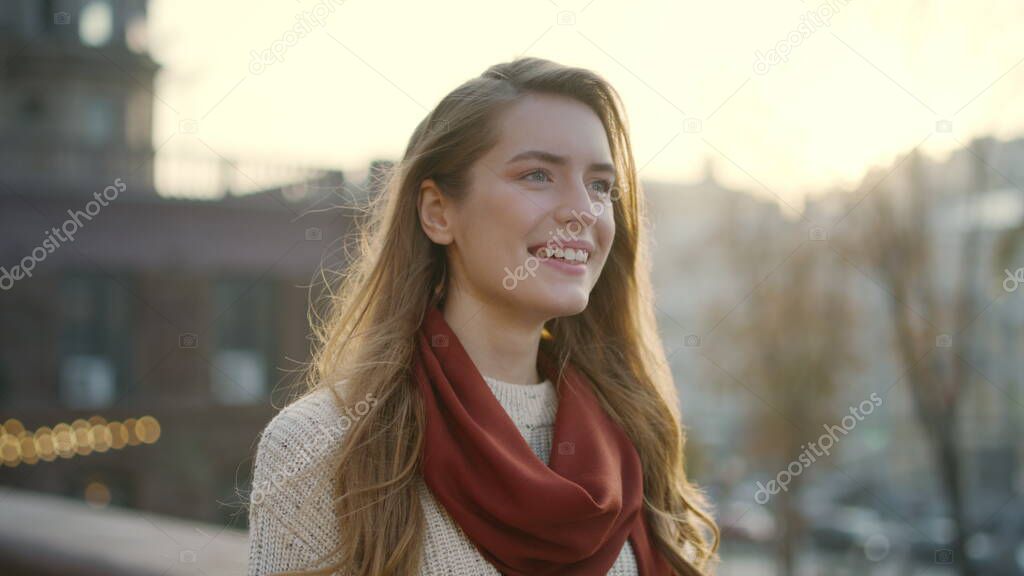 Sweet woman smiling on street. Portrait of cheerful girl walking outdoors.