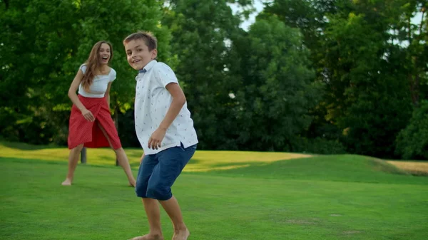 Mutter wirft Ball im grünen Feld. Eltern und Kinder spielen im Park mit Ball — Stockfoto