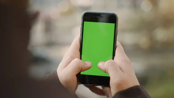 Guy hands touching cellphone green screen. Man texting by mock up phone outside — Stock Photo, Image