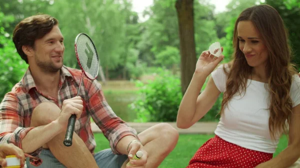 Man och kvinna håller badminton racketar utanför. Barn blåser såpbubblor — Stockfoto