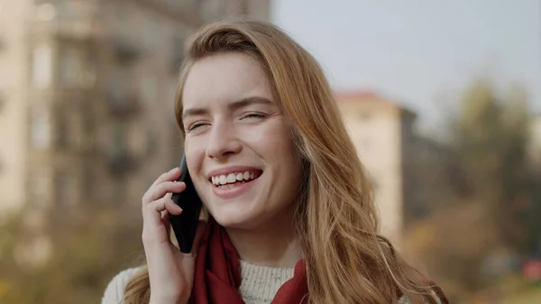 Onnellinen nainen soittaa kännykkään ulkona. Hymyilevä tyttö puhuu matkapuhelin. — kuvapankkivalokuva