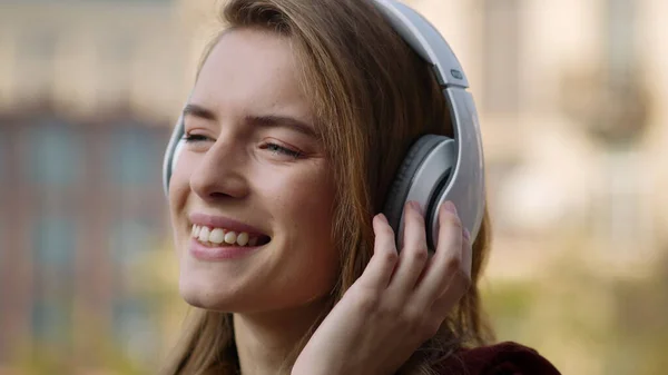 Happy woman listening music headphones outdoors. Smiling girl dancing on street. — Stock Photo, Image