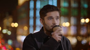 Rahat adam Dark Street 'te kahve içiyor. Elinde kağıt bardak tutan sakin adam..