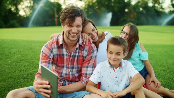 Familjen ringer på webkamera med surfplatta utomhus. Barn och föräldrar med kudde — Stockfoto