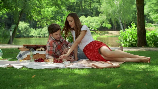 Kvinna och man tillbringar tid på picknick utanför. Kille och flicka sitter på filt — Stockfoto