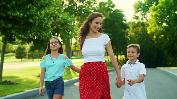 Щаслива мати з дітьми, що ходять у парку. Сімейна зустріч батька на відкритому повітрі — стокове фото