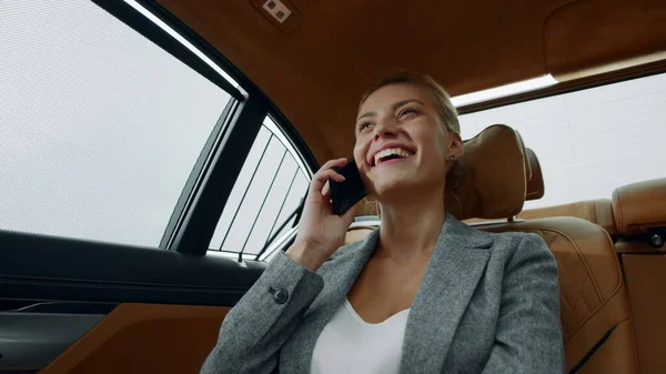 Smiling woman having phone talk in taxi. Businesswoman talking phone at car