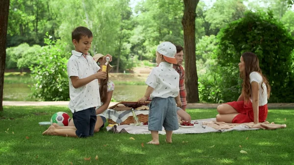 Familjen tillbringar tid i parken. Föräldrar med barn som har picknick — Stockfoto