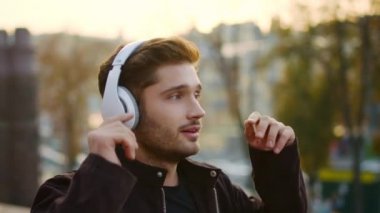 Dışarıda müzik kulaklığı dinleyen duygusal bir adam. Yürüyüşte şarkı söyleyen heyecanlı adam