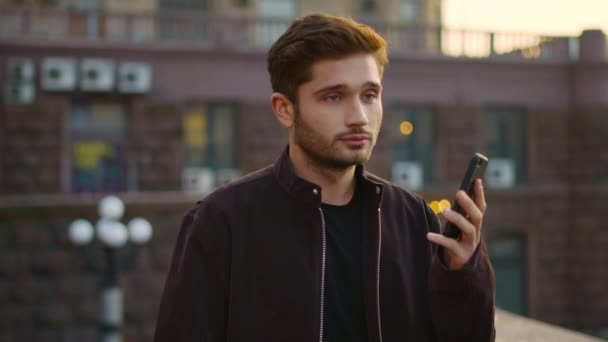 Cheerful guy speaking smartphone on street. Happy man calling cellphone outdoors — Stock Video