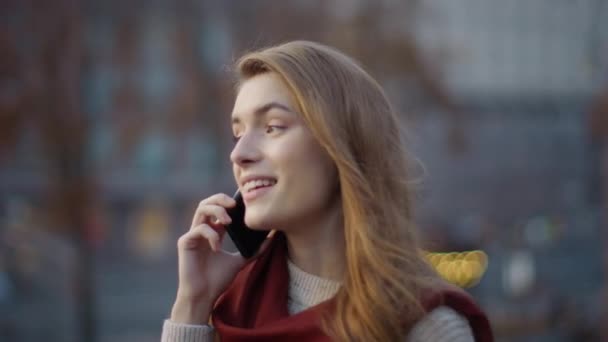 Радостная девушка говорит по телефону на улице. Женщина-хипстер гуляет с телефоном на улице . — стоковое видео