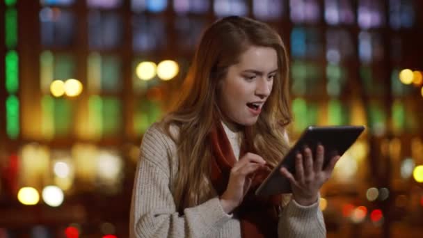 Щаслива леді отримує повідомлення на вулиці. Захоплена дівчина дивиться екран планшета — стокове відео