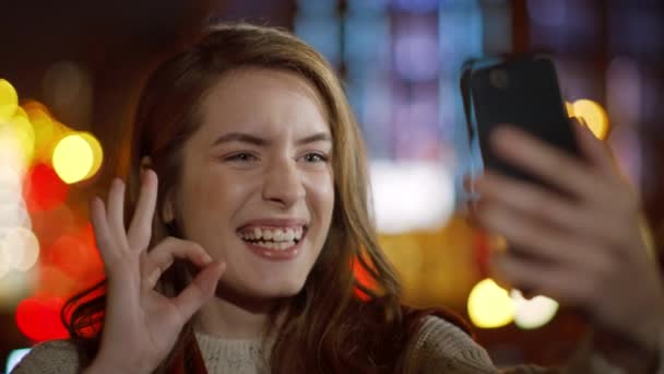 Χαμογελαστή γυναίκα που βγάζει σέλφι από κινητό τηλέφωνο. Κορίτσι δείχνει ok χειρονομία σε εξωτερικούς χώρους — Αρχείο Βίντεο