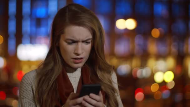 Böse Frau liest SMS-Handy im Freien. Wütendes Mädchen sucht Handy-Bildschirm