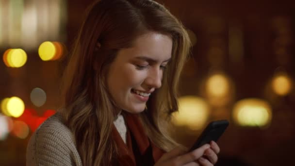 Dromerige vrouw die een berichttelefoon op straat stuurt. glimlachend meisje ontspannen met telefoon. — Stockvideo