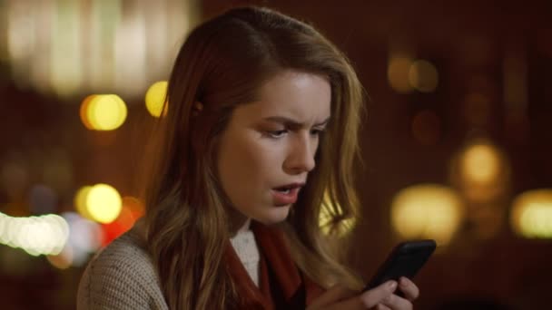 Zdenerwowana dziewczyna czyta SMS-y na zewnątrz. Zszokowana kobieta odbierająca wiadomość — Wideo stockowe