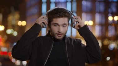 Heyecanlı adam sokakta müzik kulaklığı dinliyor. Dışarıda dans eden öforik adam..