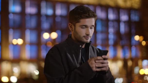 Un homme calme envoyant un texto sur son portable dans la rue sombre. gars détendu tapant smartphone — Video