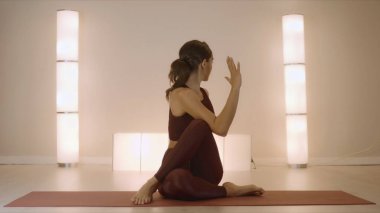 Omurga bükme pozu veren bir kadın. Stüdyoda yoga yapan formda bir kız.