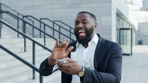 Businessman throwing money at street. Entrepreneur celebrating victory with cash