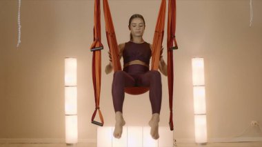 Hamakta baş aşağı asılı bir kız. Hamakta güvercin pozu veren kadın.