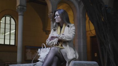 Üniversite bahçesinde bankta oturan bir öğrenci. İş kadını müşteri bekliyor.